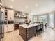 Modern kitchen with stainless steel appliances, large island with seating, and bright lighting at 7053 S Shawnee St, Aurora, CO 80016