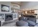 Open-concept living room featuring a fireplace, a large sofa, and views of the kitchen and the upper level balcony at 7053 S Shawnee St, Aurora, CO 80016