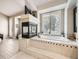Inviting main bathroom featuring a soaking tub with fireplace and a large window at 7053 S Shawnee St, Aurora, CO 80016