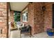 Relax on the covered front porch, complete with stylish seating and a charming brick facade at 7053 S Shawnee St, Aurora, CO 80016