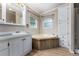 Bathroom featuring tub, built-in linen cabinet, and light vanity at 205 Spruce Ave, Lochbuie, CO 80603