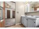 Bathroom with a light vanity, view to carpeted bedroom at 205 Spruce Ave, Lochbuie, CO 80603