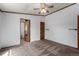 Bedroom with neutral carpet, wood trim, fan, and doorway to bathroom at 205 Spruce Ave, Lochbuie, CO 80603