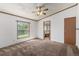 Carpeted bedroom featuring a ceiling fan and a bright window showcasing outdoor views at 205 Spruce Ave, Lochbuie, CO 80603