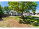 Well maintained single-story home with a large tree, manicured lawn and mature landscaping at 205 Spruce Ave, Lochbuie, CO 80603