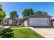 Charming single-story home with gray siding, manicured lawn and a two car garage at 205 Spruce Ave, Lochbuie, CO 80603