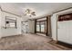 Inviting living room featuring neutral carpet, a ceiling fan, and views into the kitchen at 205 Spruce Ave, Lochbuie, CO 80603