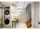 Basement laundry room with side-by-side washer and dryer, table, and stairs at 460 S Sherman St, Denver, CO 80209