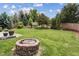 Spacious backyard with lush green lawn and fire pit at 2934 Braeburn Way, Highlands Ranch, CO 80126
