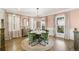 Charming dining room with a round table, green velvet chairs, and bright natural light at 5880 Beeler Ct, Denver, CO 80238