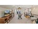 Bright game room features a foosball table, bar area with beverage fridge, and balcony access through French doors at 5880 Beeler Ct, Denver, CO 80238