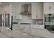 Modern kitchen with white cabinets, stainless steel appliances, and a large quartz countertop island at 5880 Beeler Ct, Denver, CO 80238
