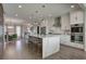 Modern kitchen with a waterfall island, stainless steel appliances, and an adjoining dining room at 5880 Beeler Ct, Denver, CO 80238