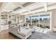 Spacious living room with large windows, coffered ceilings, built-in shelving, and access to an outdoor patio at 5880 Beeler Ct, Denver, CO 80238