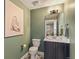 Charming powder room with patterned floors, green walls, and a stylish vanity with modern fixtures at 5880 Beeler Ct, Denver, CO 80238