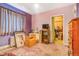 View of a bedroom with pink carpet, mauve walls, a TV, and an open door with belongings inside at 2421 N York St, Denver, CO 80205