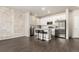 Modern kitchen featuring stainless steel appliances, a granite island with bar stools, and an exposed brick wall at 1353 Reynolds St # 16B, Fort Lupton, CO 80621