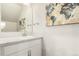 Bright powder room with a marble countertop vanity and decorative mirror, offering a stylish and functional space at 1353 Reynolds St # 16B, Fort Lupton, CO 80621