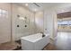 A contemporary bathroom featuring a modern bathtub, glass shower, and stylish tile flooring at 27381 E Lakeview Dr, Aurora, CO 80016