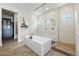 A contemporary bathroom featuring a modern bathtub, glass shower, and stylish tile flooring at 27381 E Lakeview Dr, Aurora, CO 80016