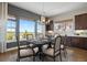 Bright dining room with large windows, a dark wood table, and an adjacent kitchen area at 27381 E Lakeview Dr, Aurora, CO 80016