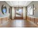Elegant dining room boasts hardwood floors, stylish chandelier, modern wainscoting, and large window at 27381 E Lakeview Dr, Aurora, CO 80016