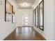 Bright hallway with hardwood floors, decorative mirrors, and modern lighting fixtures at 27381 E Lakeview Dr, Aurora, CO 80016