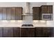 Close up of modern kitchen with stainless steel appliances, dark wood cabinets and quartz countertops at 27381 E Lakeview Dr, Aurora, CO 80016