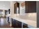 Modern kitchen featuring dark wood cabinetry, quartz countertops, a wine fridge and hardwood floors at 27381 E Lakeview Dr, Aurora, CO 80016