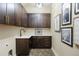 Well-appointed laundry room offers ample cabinet space, countertop, and herringbone tile flooring at 27381 E Lakeview Dr, Aurora, CO 80016