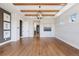 A light-filled room featuring hardwood floors, beamed ceilings, and access to the hallway at 27381 E Lakeview Dr, Aurora, CO 80016