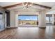 Spacious open-concept living room with wood floors, stone fireplace, and an expansive sliding glass door leading to a patio at 27381 E Lakeview Dr, Aurora, CO 80016