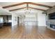 Open-concept floor plan featuring wood floors, exposed beams, fireplace, and adjacent kitchen with island at 27381 E Lakeview Dr, Aurora, CO 80016