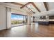 Open-concept living room with wood floors, vaulted ceiling and exposed beams, and a walkout to a patio at 27381 E Lakeview Dr, Aurora, CO 80016