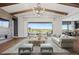 Stylish living room with vaulted ceilings, a fireplace, backyard views, and open access to the dining area at 27381 E Lakeview Dr, Aurora, CO 80016