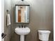Stylish powder room features a modern pedestal sink, geometric wallpaper, and sleek fixtures at 27381 E Lakeview Dr, Aurora, CO 80016