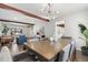 Open-concept dining room with beams, wood floors, stylish furniture, and connecting to living room at 7076 W 83Rd Way, Arvada, CO 80003