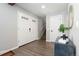 Bright entryway with gray walls, wood floors, white trim, and coat closet, leading to the stairs at 7076 W 83Rd Way, Arvada, CO 80003