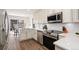 Modern kitchen with white cabinets, stainless steel appliances, and quartz countertops at 7076 W 83Rd Way, Arvada, CO 80003