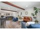 Open concept living room with brown leather sofa, beams, and large picture window at 7076 W 83Rd Way, Arvada, CO 80003