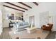 Open-concept living room with wood beam ceilings and lots of natural light at 7076 W 83Rd Way, Arvada, CO 80003