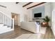 Bright living room with wood-beam ceilings, stylish accent wall, tiled fireplace, and hardwood floors at 7076 W 83Rd Way, Arvada, CO 80003