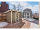 Useful sheds in backyard provides extra storage, set against a backdrop of trees and gravel at 7076 W 83Rd Way, Arvada, CO 80003