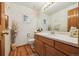 Bathroom featuring light-toned wallpaper, wood floor, and wooden cabinets at 5134 S Ouray Ct, Centennial, CO 80015
