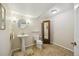 Charming bathroom featuring a pedestal sink, decorative mirror, and tile flooring at 5134 S Ouray Ct, Centennial, CO 80015