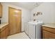 Well lit laundry room has a side-by-side washer and dryer and includes built in cabinets at 5134 S Ouray Ct, Centennial, CO 80015