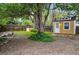 Backyard with a shed, large tree, and landscaping with stone and mulch at 9390 W 14Th Ave, Lakewood, CO 80215
