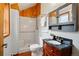 Cozy bathroom featuring a walk-in shower with a rustic wood paneled accent wall and a black granite vanity at 9390 W 14Th Ave, Lakewood, CO 80215