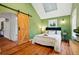 Bright bedroom with green walls, a skylight and a rustic wooden barn door at 9390 W 14Th Ave, Lakewood, CO 80215
