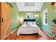 Bright bedroom with green walls, a skylight and a rustic wooden barn door at 9390 W 14Th Ave, Lakewood, CO 80215